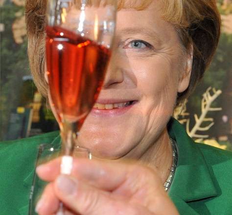 and German Chancellor Angela Merkel drinks a glass of sparkling rose wine during the sponsors' tour at the CDU Federal Party Conference in Leipzig, Germany, 15 November 2011. From 14 to 15 November 2011, the CDU's 24th federal convention takes place in Leipzig. EPA/PETER ENDIG
